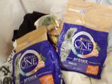 two bags of cat food on a bed next to a banana