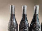 four bottles of wine are lined up on a table