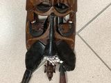 a wooden mask hanging on the wall on the floor