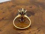 an image of a gold ring with a black diamond
