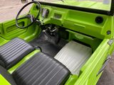 a green truck with a black seat and steering wheel