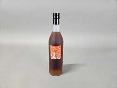 une bouteille de sirop posée sur une surface blanche