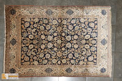 un tapis persan ancien posé sur un sol carrelé