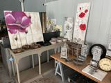 many pieces of art on a table in a room
