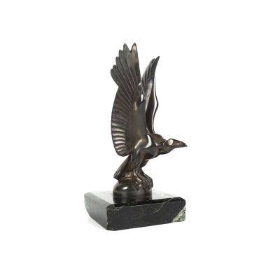 sculpture en bronze représentant un oiseau, posée sur un socle en marbre, sur fond blanc