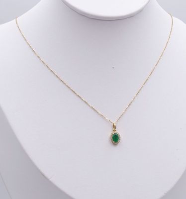 un collier en or avec un pendentif en pierre verte sur un mannequin