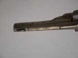 a gun that is on a table with a white wall in the background