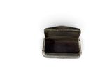an old silver box with a black lid on a white surface