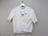 the white shirt is hanging on a hanger on the wall