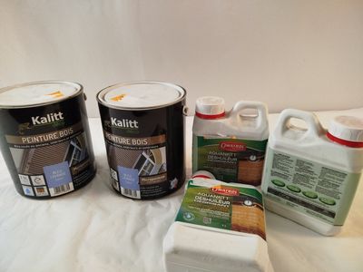 three cans of paint and two cans of paint sitting on a table