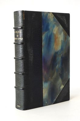 un vieux livre avec une couverture noire et une couverture bleue et violette