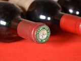 several bottles of wine are lined up on a red table