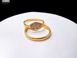 deux bagues en or ornées d'un diamant sur un fond blanc
