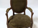 an old chair with a green velvet upholstered seat