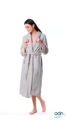 a woman in a robe standing with her hand in her pocket