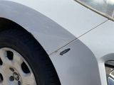 a close up of a car ' s front bumper with a denting on it
