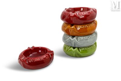 une pile de quatre cendriers de couleurs différentes sur un fond blanc