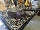 une statue représentant un éléphant couché sur une table