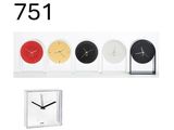 cinq horloges de couleurs différentes posées sur une étagère, avec une horloge au milieu
