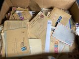 a cardboard box full of old letters and envelopes