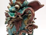 a statue of a dragon that is sitting on a rock