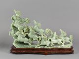 sculpture of a group of horses on a wooden base on a gray background