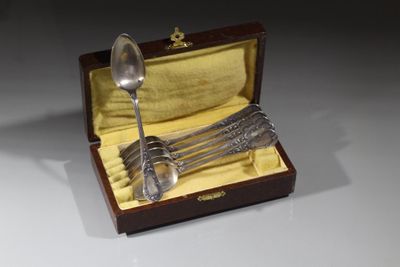 une cuillère en argent et un service de cuillères dans un coffret en bois