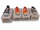 quatre paires de chaussures sont alignées sur des boîtes posées sur une surface blanche