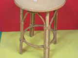une petite table en bois avec un plateau rond posée sur un sol jaune
