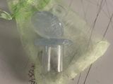 un petit sac orné d'un ruban vert posé sur une feuille de papier