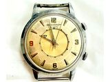 une montre en argent avec un cadran jaune sur fond blanc