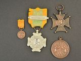 three medals and a medal sitting on a table next to each other