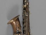 a close up of a saxophone on a gray surface