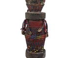 a statue of a man made out of wood and beads
