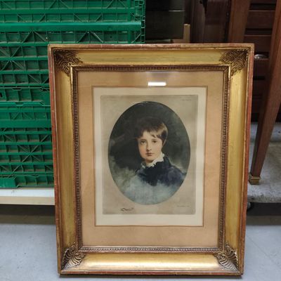 une vieille photo d'un jeune garçon dans un cadre doré