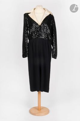 une robe noire et blanche à paillettes posée sur un socle de mannequin