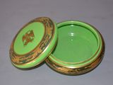 a green and gold box with a lid on a table