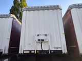 three semi trailers parked side by side in a parking lot