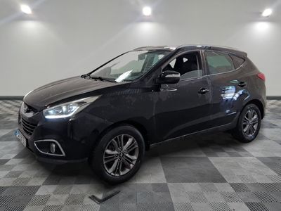 la voiture noire est garée sur un sol en damier dans le garage