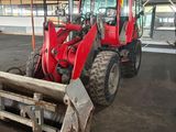 a red tractor that is parked inside of a building