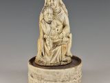 une figurine en ivoire sculpté représentant une femme tenant un enfant dans ses bras