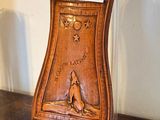 une horloge en bois posée sur un socle, elle-même posé sur une table