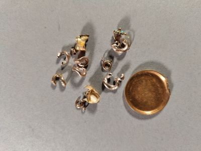une pièce d'or à côté d'une boucle d'oreille en argent et en or