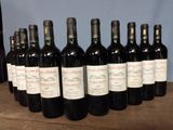 several bottles of wine are lined up on a wooden table