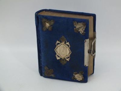 un petit livre bleu orné de motifs dorés