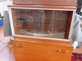 a small wooden cabinet with a glass door on top of it