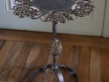 une petite table en métal ornée d'un motif floral