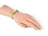 a close up of a person ' s hand wearing a gold bracelet