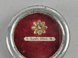 a close up of a small red box with a gold flower on it