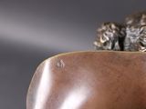 a bronze statue of a dog laying on top of a pillow